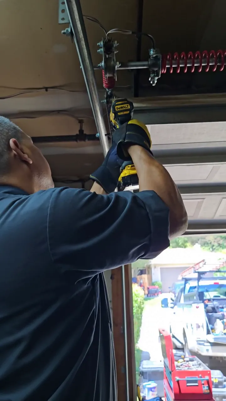 A TishTush Services technician repairing a garage door — the kind of crew Sophie answers for